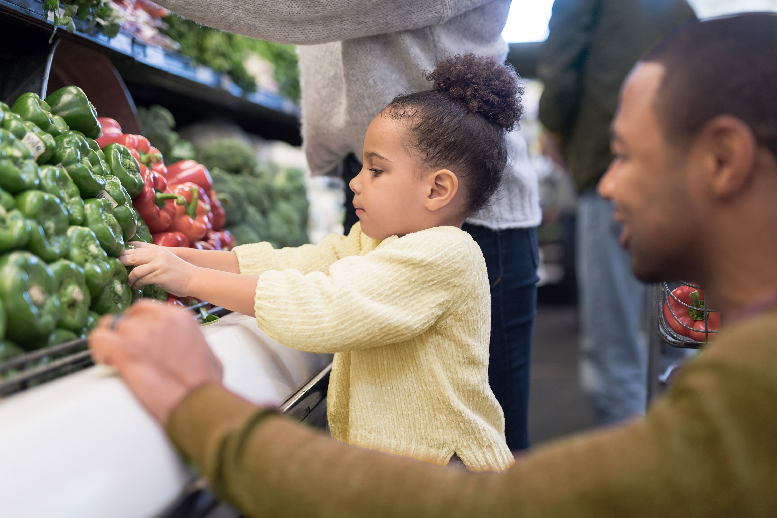 man and child shopping for vegetables
