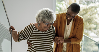 Image of an older woman being helped by a younger woman